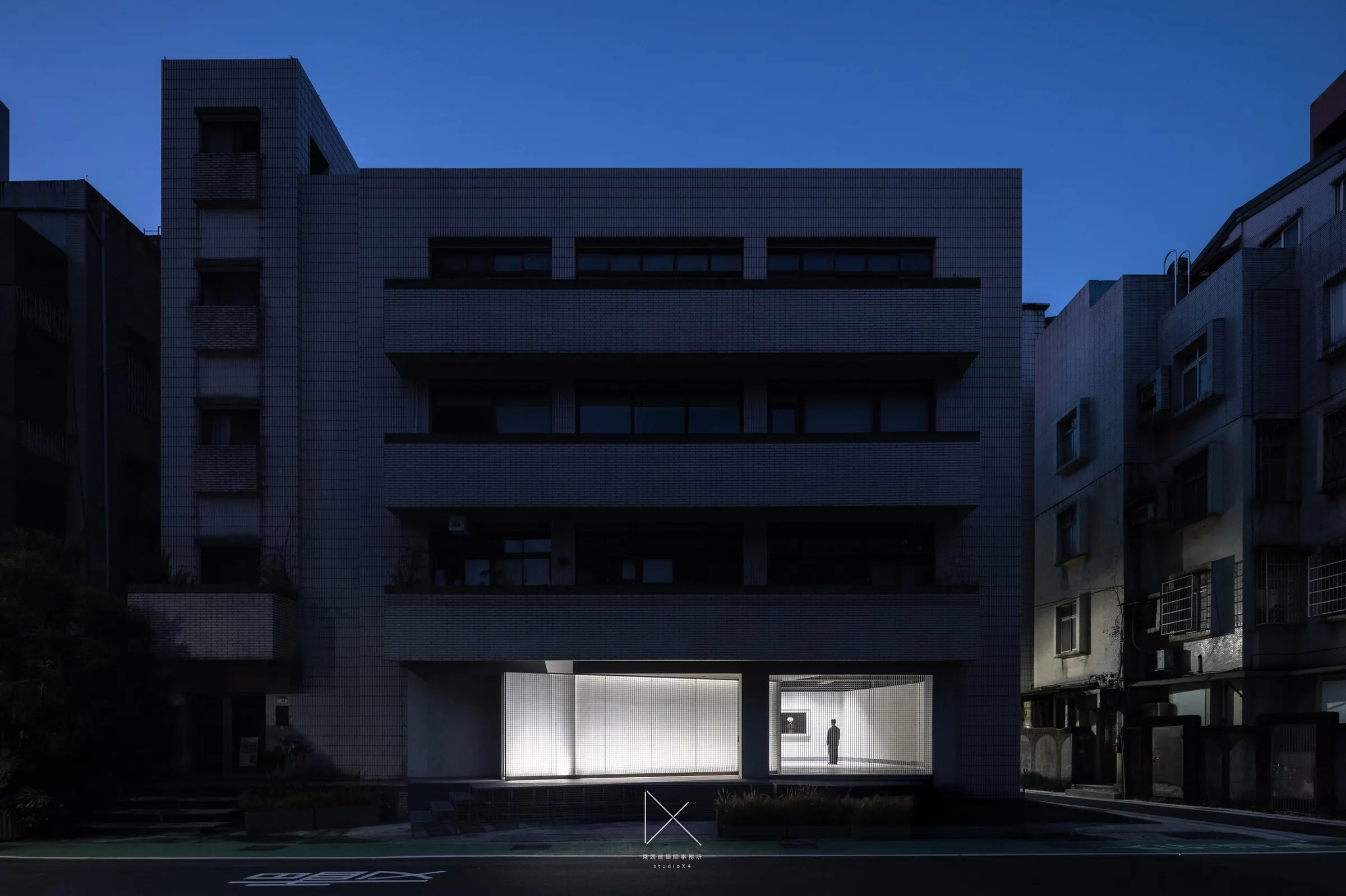夜間建築正立面,一樓展間燈光點亮整棟量體。