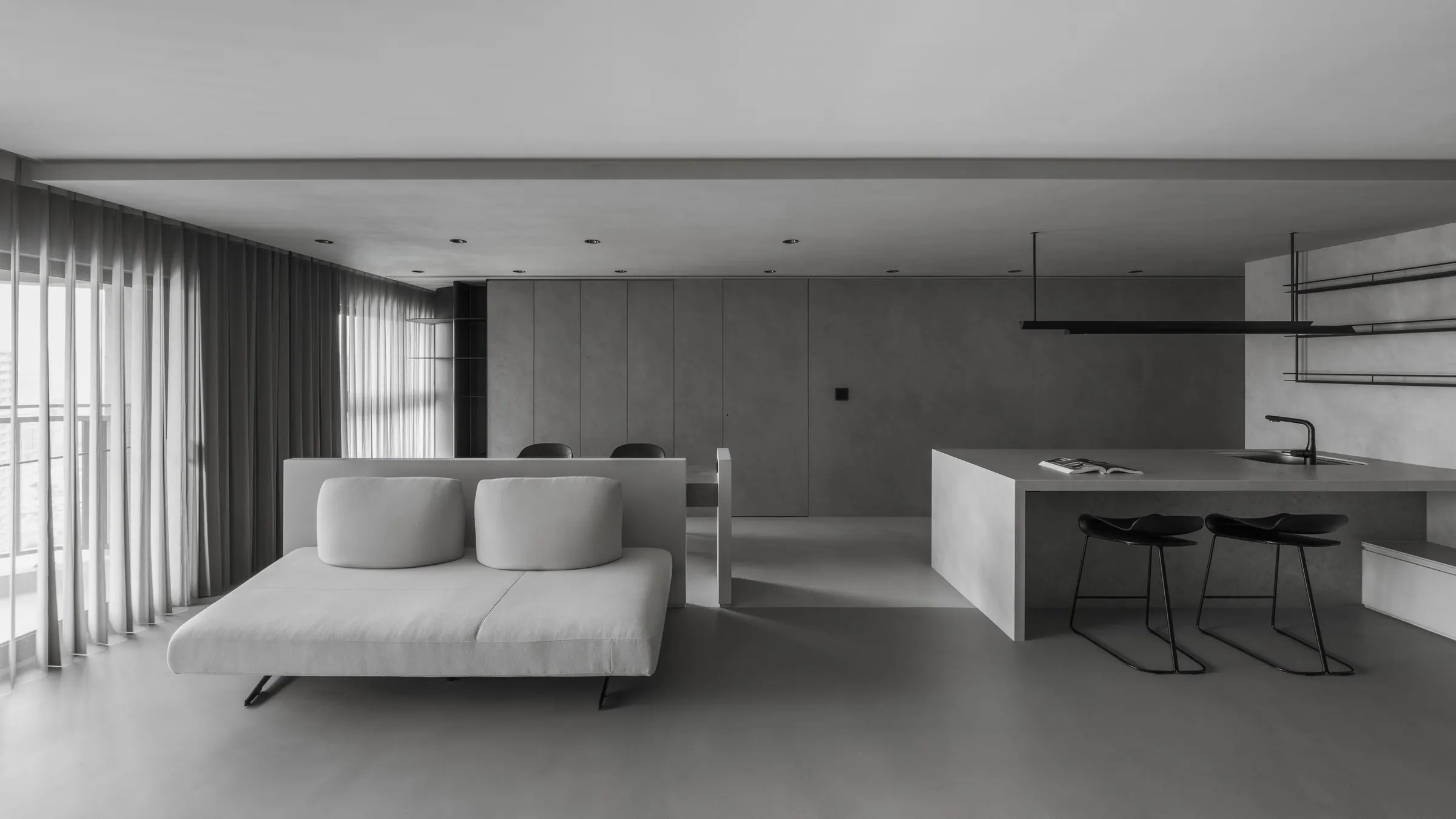 Stone Serenity 把客廳磨成一整片灰,沙發浮在中央,石質吧檯接住兩張高腳椅