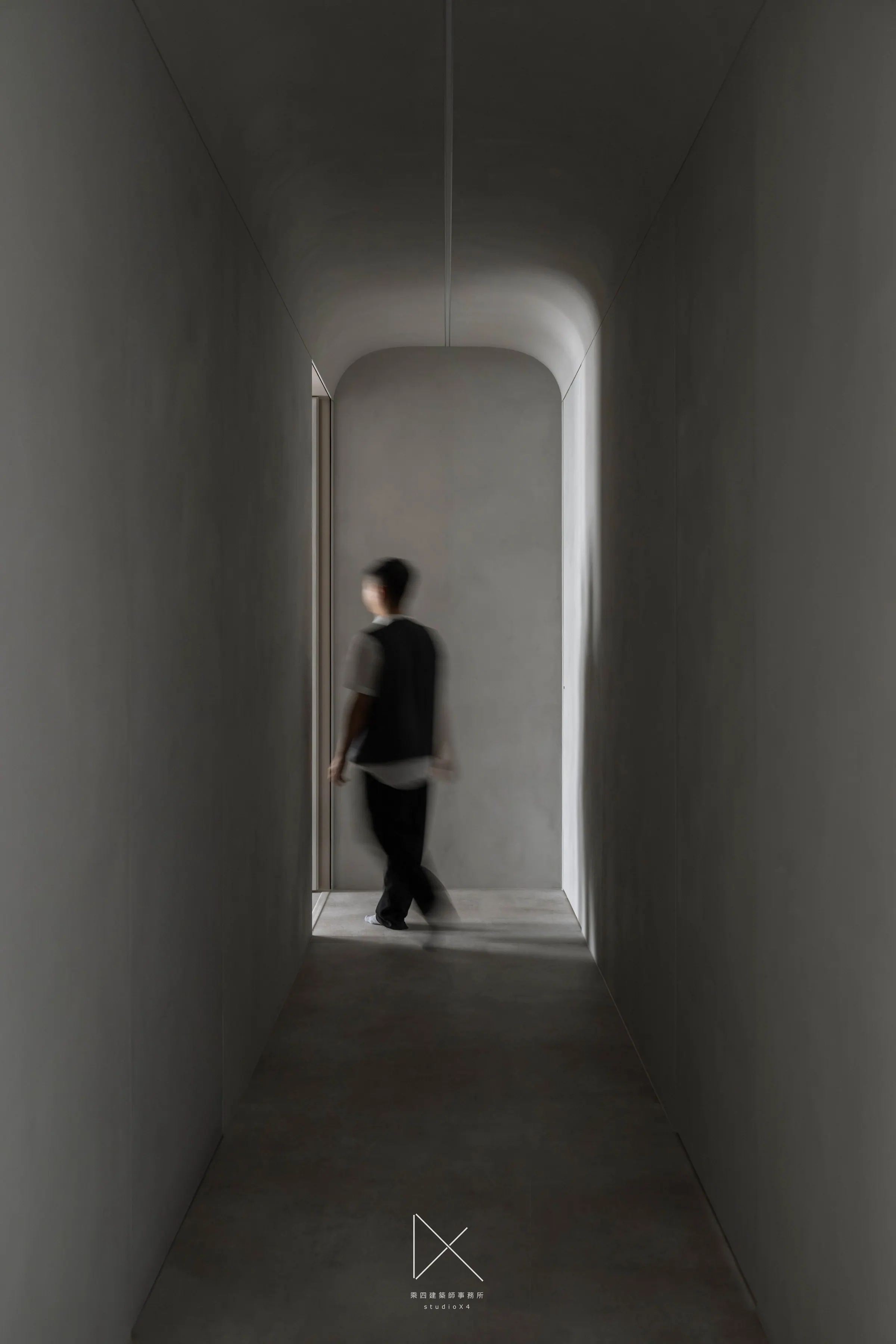 TanResidence 的廊道收窄再打開,圓角門洞透進光,人影正要走出去